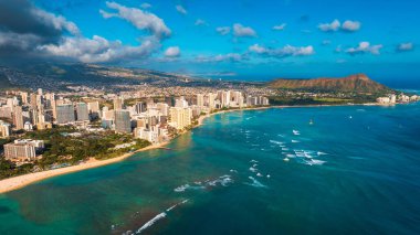 Köpüklü jantlı dalgalar kıyıya vuruyor. Pasifik Okyanusu 'nun yüksek su manzarası. Waikiki tatil köyü otelleri kıyı şeridinde. Arkaplanda Diamond Head Carter.