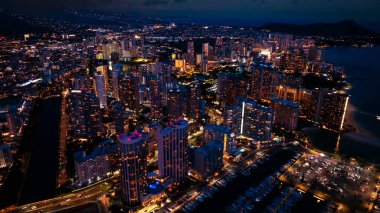 Waikiki 'nin gece manzarası. Alacakaranlıkta muhteşem aydınlatılmış şehir manzarası. Hava görünümü.