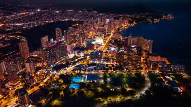 Waikiki 'nin gece manzarası. Alacakaranlıkta muhteşem aydınlatılmış şehir manzarası. Hava görünümü.