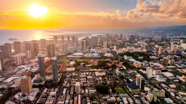 Honolulu, Hawaii, ABD manzarasını kaplayan inanılmaz altın ışık. Gün batımında şehrin üzerinde insansız hava aracı görüntüleri.