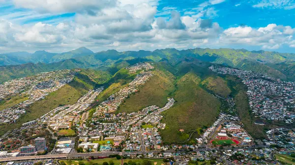 Dağlar ve yamaçlar arasında vadi boyunca yayılmış yoğun özel evler. Honolulu, Hawaii, ABD manzaralı. Hava perspektifi.