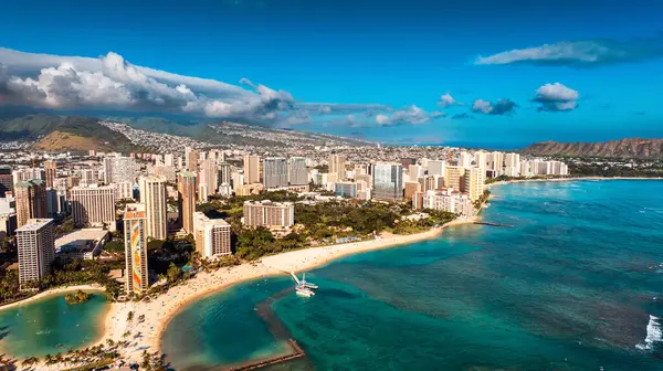 Büyük yat kulübüne doğru Pasifik Okyanusu 'nun turkuaz su manzarası. Bulutların altındaki Honolulu, Hawaii, ABD manzarasına hava perspektifi.