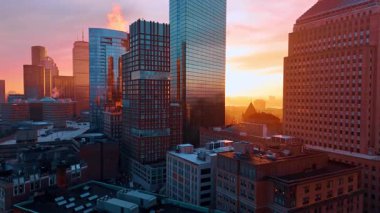 Batan güneşin turuncu ışığı ayna kulelerinin cephelerine yansıyor. Modern Boston, Massachusetts, ABD 'de alacakaranlık zamanı. Hava görünümü.