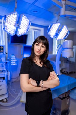 Modern ameliyathane ortamında bir cerrah. Sağlık bakımı uzmanı gelişmiş cerrahi ekipman ve ışıklandırma ile yüksek teknolojili bir ameliyathanede güvenle duruyor..