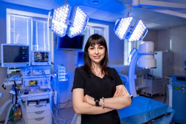 Geleceğe ait bir ameliyathanede doktor. Güvenilir bir sağlık uzmanı yüksek teknolojili bir ameliyathanede ameliyata hazır bekliyor..