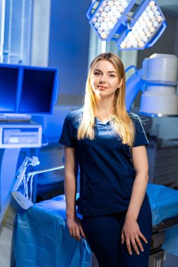 Cerrahi ortamında tıbbi uzman. Bir sağlık çalışanı, iyi aydınlatılmış bir cerrahi ortamda güvenli bir şekilde poz verir ve bir sonraki işleme hazırdır..