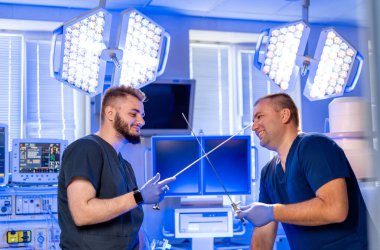 Cerrahlar içeride idman yapıyor. İki cerrah, modern bir ameliyathanede parlak ışıklandırmalı cerrahi aletlerle kılıç dövüşünü taklit ediyor..