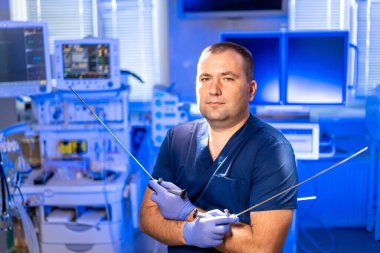 Cerrah ameliyata hazırlanıyor. Ameliyat önlüklü bir cerrah, iyi donanımlı bir ameliyathanede kendine güvenen bir cerrah olarak durur..