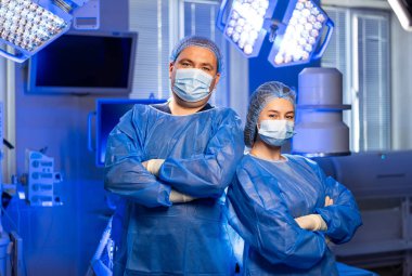 Doktorlar ameliyata hazır. İki tıp uzmanı ameliyata başlamak için güvenli bir şekilde ameliyathanede bekliyorlar..