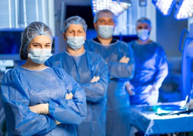 Tıbbi ekip tarafından ameliyat hazırlığı. Mavi önlüklü tıbbi uzmanlardan oluşan bir ekip yaklaşan cerrahi müdahaleye emin bir şekilde hazırlanıyor..