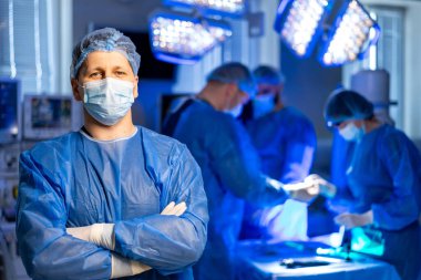 Cerrah ameliyathanede hazır olsun. Bir cerrah, ameliyata hazır modern bir ameliyathanede güvenle duruyor..