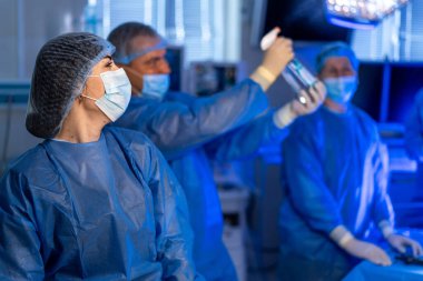 Hastanede ameliyat hazırlığı var. Odaklanmış sağlık uzmanları iyi donanımlı bir hastane ameliyathanesinde ameliyata hazırlanıyorlar..