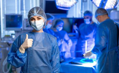 Kendine güvenen cerrahi ekip iş başında. Tıbbi profesyoneller, kritik bir operasyonda takım çalışması ve hassasiyeti sergilemek için bir cerrahi odada birlikte çalışırlar..