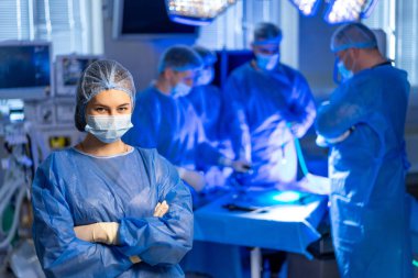 Tıbbi ekip tarafından ameliyat. Cerrahlar ve çalışanlar ameliyathanede birlikte çalışırlar. Hasta ameliyatı için ekip çalışması ve hassasiyete odaklanırlar..