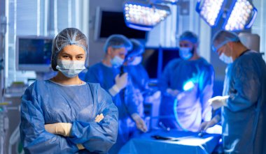 Cerrahi ekip hastanede hazır. Bir cerrahi ekibi iyi donanımlı bir hastane ortamında odaklanmış ve dikkatli bir şekilde ameliyata hazırlanıyor..