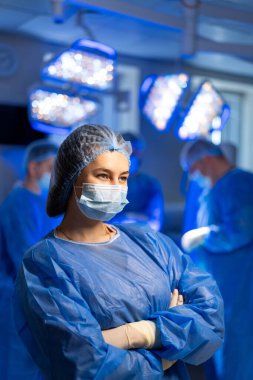 Tıbbi ekip ameliyathanede çalışıyor. Yetenekli cerrahlar ve hemşireler ameliyata hazırlanıyor, steril bir ortamda hasta bakımına odaklanıyorlar..