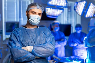 Cerrahlar ameliyata hazırlanıyor. Tıbbi ekip modern bir ameliyathanede parlak ışıkları ve gelişmiş teknolojisi olan ameliyata hazırlanıyor..