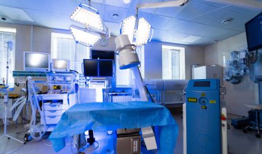 Yüksek teknoloji cerrahi odası. Parlak ışıklandırılmış cerrahi odası karmaşık tıbbi ekipmanlara ve steril ortama sahip, prosedürlere hazır..