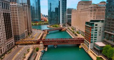 Motorlu tekne, Chicago Nehri üzerindeki köprünün altındaki masmavi su manzarasının yanında yüzüyor. İHA görüntüleri Chicago, Illinois, ABD 'de..