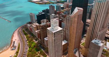 Michigan Gölü kıyısındaki güzel gökdelenler boyunca iniyor. Göl kenarındaki otobanlardan bir sürü araba geçiyor..