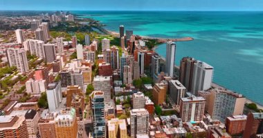 Michigan Gölü kıyısında, Chicago 'nun güneşli manzarası. İHA görüntüleri şehir merkezindeki geniş şehir ve turkuaz su manzarasını gözler önüne seriyor..