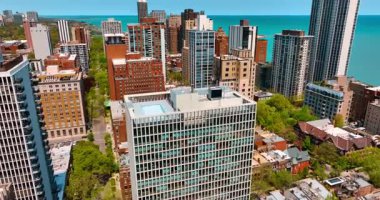 Chicago, Illinois, ABD kıyısı yakınlarındaki çok katlı bir ofis binasına yaklaşıyoruz. Çevrede yüksek binalar var. Hava görünümü.