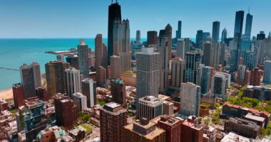 Chicago, Illinois, ABD 'nin modern şehir merkezine yaklaşıyoruz. Metropolün güzel ufuk çizgisi mavi su manzarasının arka planında. Hava görünümü.