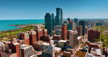 Alt tuğlaların arasında duran yüksek katlı cam binalar. Arka planda inanılmaz mavi su manzarası. Chicago, Illinois, ABD.