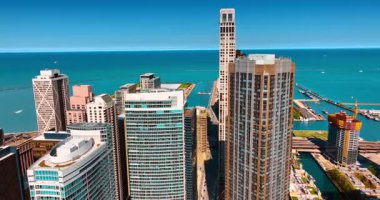 Şehrin liman bölgesinde birbirine yakın duran gökdelenler. Sonsuz mavi su manzarasının arkaplanındaki güzel binalar. Chicago, Illinois, ABD.