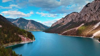Plansee Gölü 'nün huzurlu mavi suları üzerinde uçmak çarpıcı dağların arasında süzülüyor. Tyrol, Avusturya 'da doğanın şaşırtıcı manzarası.