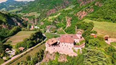 Bolzano, Güney Tyrol, İtalya 'daki güzel ortaçağ kalesi Runkelstein' in etrafında uçuş. Yamaçlarda yetişen üzüm bağları ile inanılmaz kayalık bir manzara. Hava görünümü.