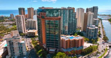 Honolulu, Hawaii, ABD 'deki Ala Wai Kanalı kıyısında cam cepheli çok katlı bir bina. İHA görüntülerinden Waikiki 'nin güneşli manzarası.