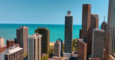 Mavi su manzarasının arka planında çeşitli çok katlı binalar. Chicago kuleleri Michigan Gölü 'nün arka planında. Üst görünüm.