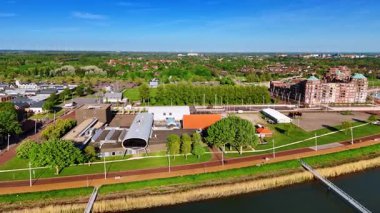 Hollanda 'daki güzel Lelystad' ın rıhtımına yaklaşıyoruz. Yeşilliklerle dolu şehrin güneşli manzarası. Üst görünüm.