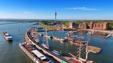 Rıhtımda gemileri olan liman. Hollanda, Lelystad 'lı Marina göl kıyısında güzel binaları var. Telekom kulesi, arka planda barajlar ve kanallar. Hava görünümü.