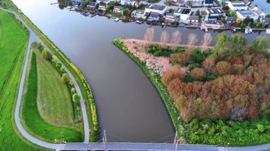 Köprünün üzerinden, kanalın kıyılarını birbirine bağlayan görüntüler. Gün batımında Hollanda 'nın güzel ülkesinin manzarası gözler önüne seriliyor.