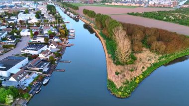 İkamet alanı boyunca kanalın ayna yüzeyinde uçuyor. Gün batımında Hollanda kırsalında.