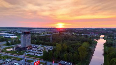 Hollanda 'nın kırsal kesiminde gün batımı. Yollar ve otoparklar üzerinde İHA uçuşu.