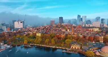 Boston, Massachusetts, ABD. Charles Nehri 'nin yukarısındaki insansız hava aracı görüntüleri canlı şehir manzarasına yaklaşıyor. Kalın duman arka planda şehri kaplıyor. Hava perspektifi.