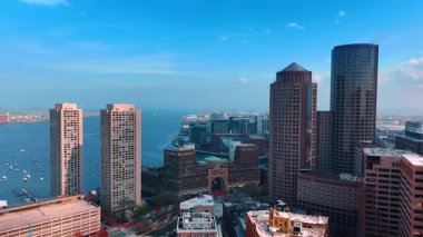 Boston, Massachusetts, ABD limanında yüksek binalar. Arka planda birden fazla yelkenli olan mavi su manzarası. Hava perspektifi.