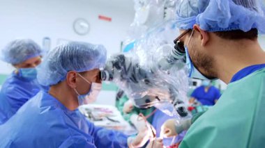 Nöroşirürji yapan doktorlar mikroskoba bakarlar. Beyin tümörü ameliyatı..