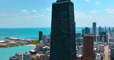 Chicago, Illinois, ABD 'deki karanlık John Hancock Merkezi' nin tepesine uçuyor. Michigan Gölü 'nün turkuaz su manzarası.