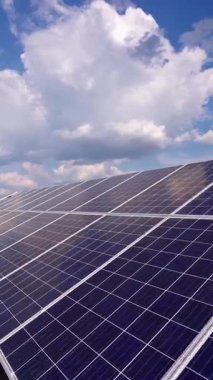 Çimlerin üzerindeki güneş panelleri. Yaz aylarında yenilenebilir yeşil enerji için güneş paneli elektrik santrali. Açık havada uzun sıra mavi paneller. Dikey video