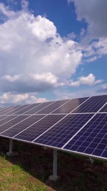Yerdeki güneş panelleri gökyüzünün altında. Güneş enerjisiyle çalışan güneş sistemi. Daha iyi bir gelecek için temiz teknoloji. Fotovoltaik panel sistemi. Dikey video