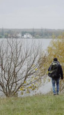 Ormanda nehrin kıyısında bir adam. Ormanda nehir manzarası arayan sırt çantalı bir turist.