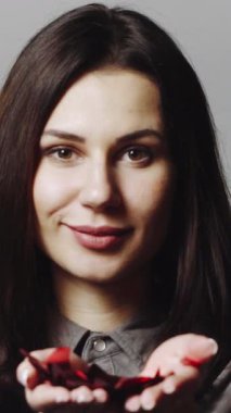 Konfeti süsleme. Stüdyoda fotoğrafçılık yaparken renkli konfeti üfleyen bir kız.