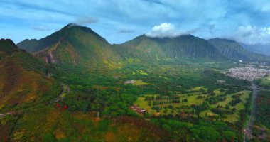 Güzel dağlarla çevrili nefes kesici yeşil vadi. Kayaların tepesindeki bulutlar. Oahu, Hawaii, ABD. Üst görünüm.