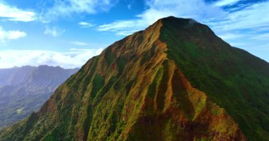 Yosunlar ve yosunlarla kaplı ulaşılmaz kayalar. Arka planda beyaz bulutlu mavi gökyüzü. Oahu, Hawaii, ABD. Üst görünüm.
