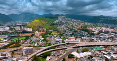 Arabalar Honolulu, Oahu, Hawaii, ABD otobanlarında ve otoyollarda çalışıyor. Arka planda dramatik bulutların altındaki sıradağlar. Hava görünümü.