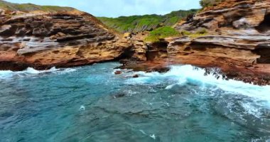 Oahu 'nun Rocky sahili, Hawaii okyanus dalgaları tarafından kıvrılmış. Köpüklü dalgalar kayalıklara çarptı. İnsansız hava aracı görüntüleri.
